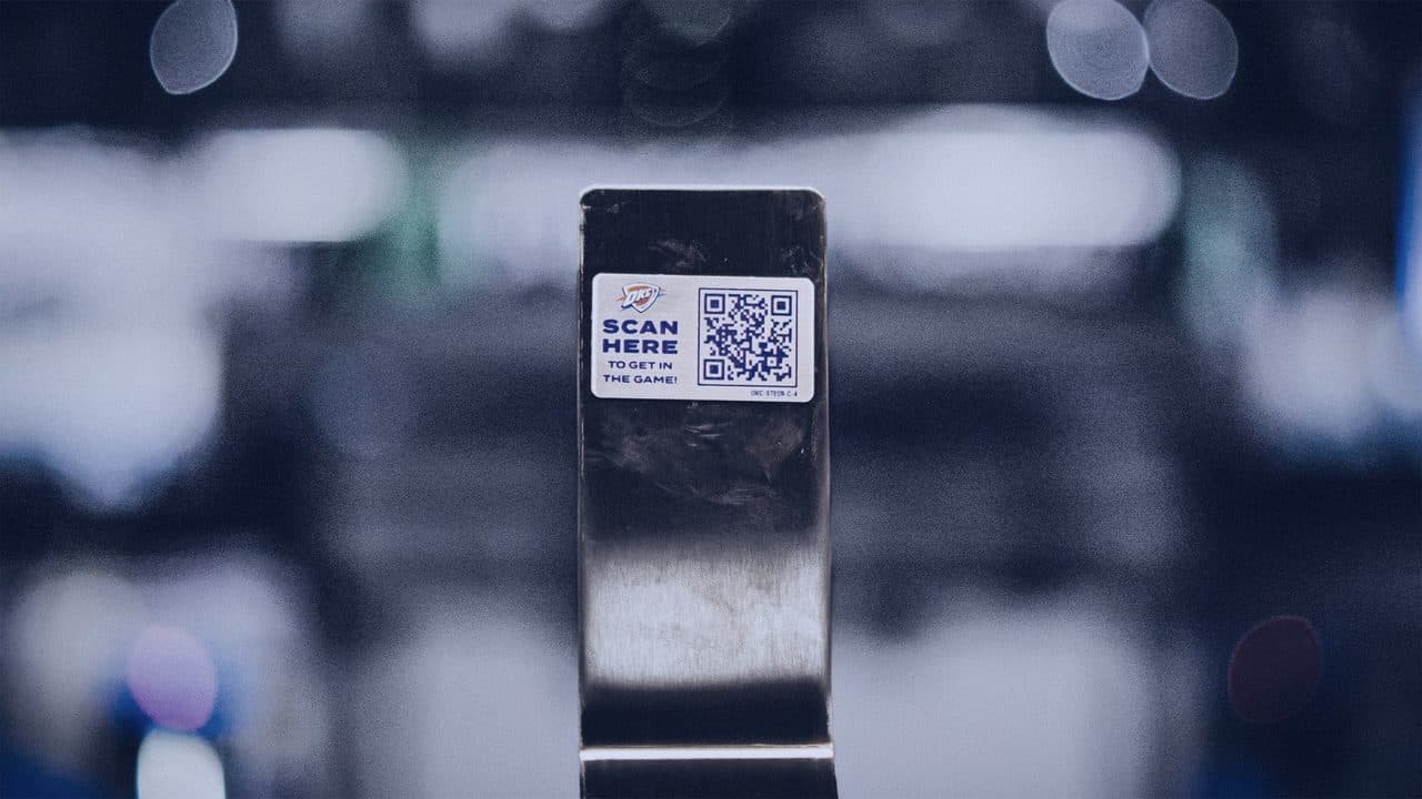 Seat-mounted QR tag with the arena bowl glowing behind it